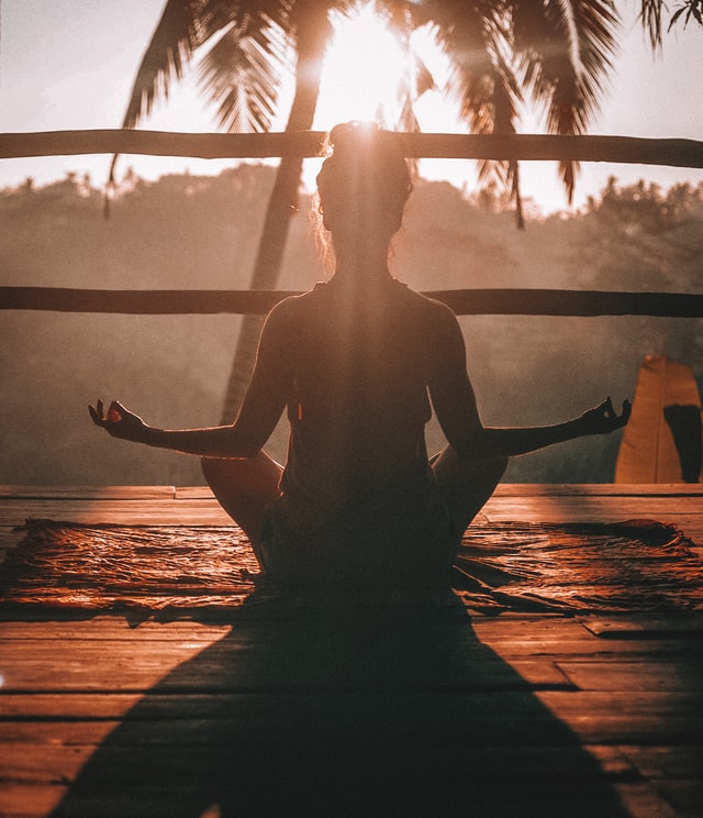 woman in yoga pose with palm tree