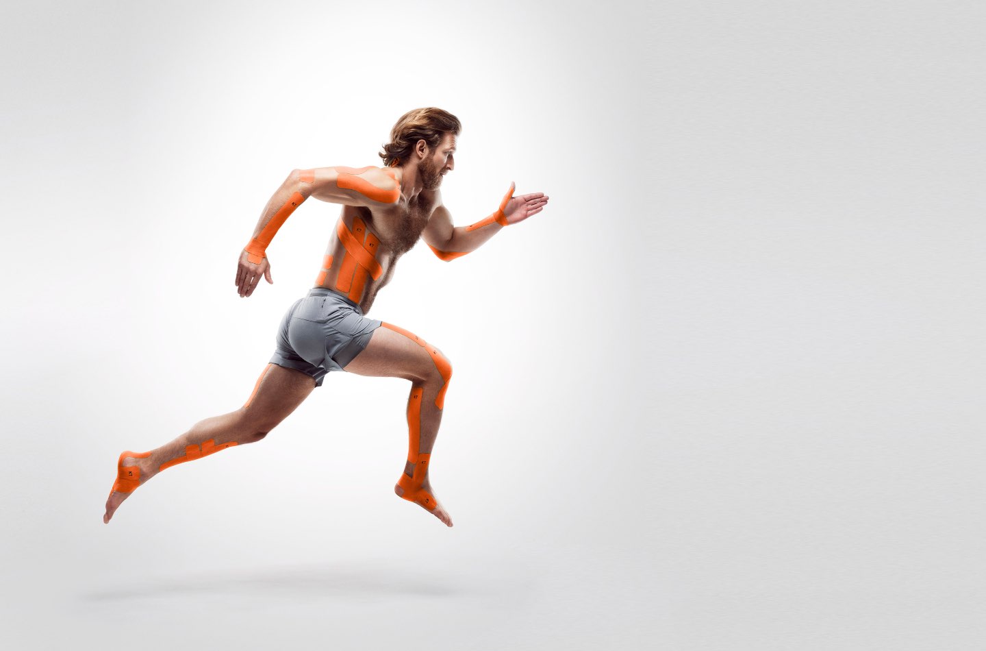 Man running with KT Tape applied on body parts