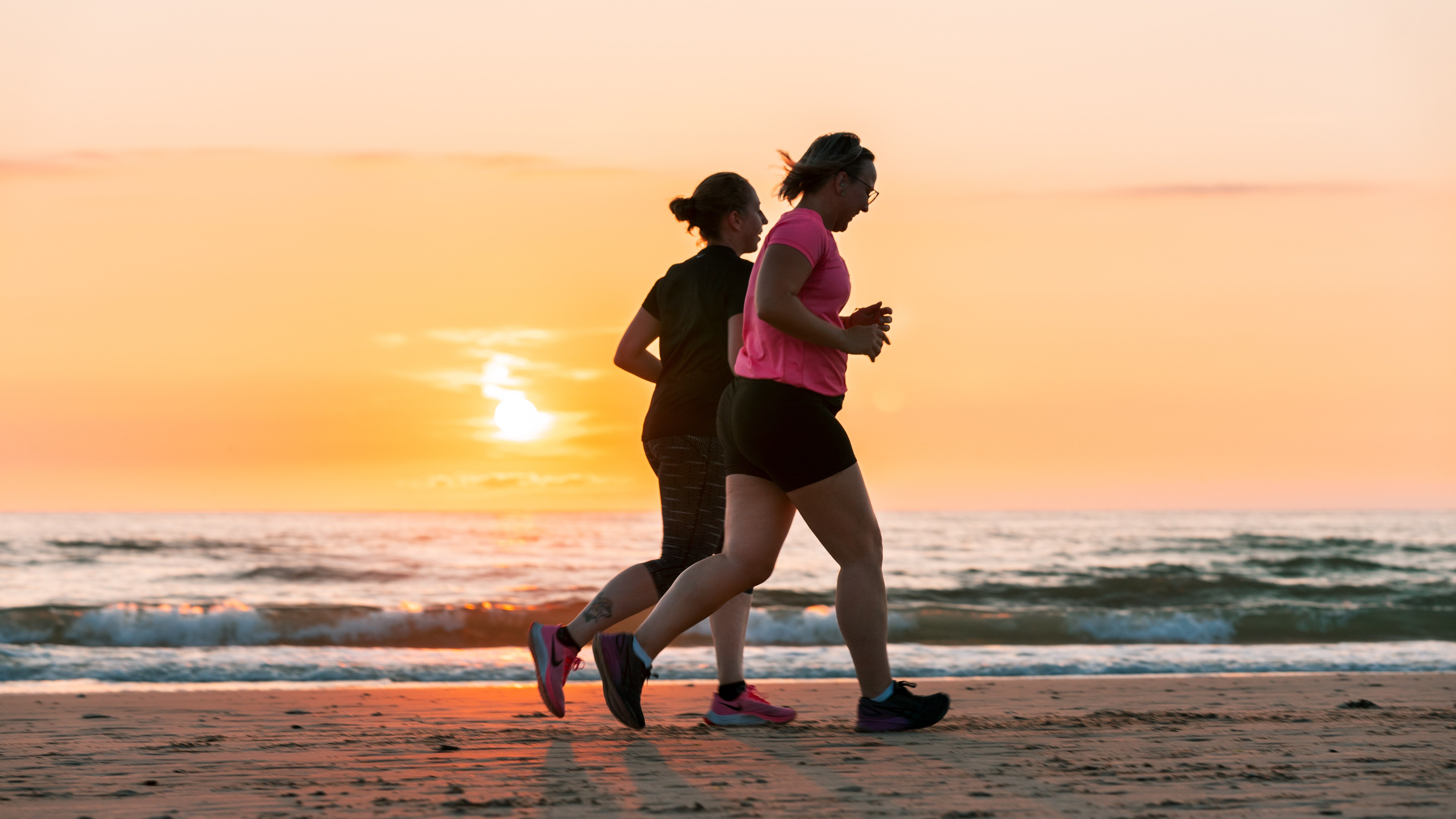 two women running on a beach