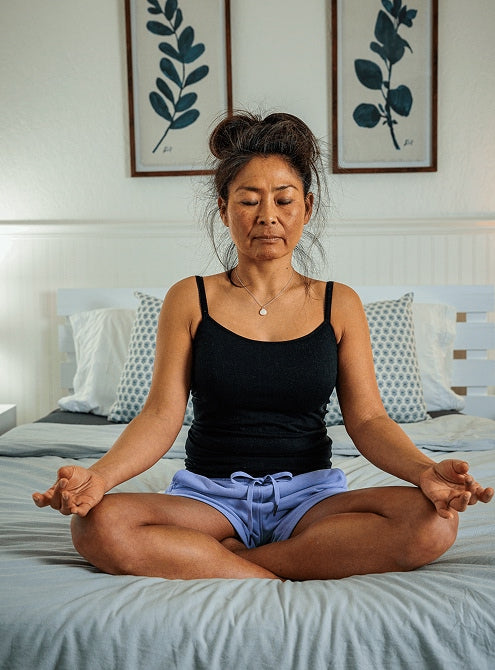 Woman meditating on bed