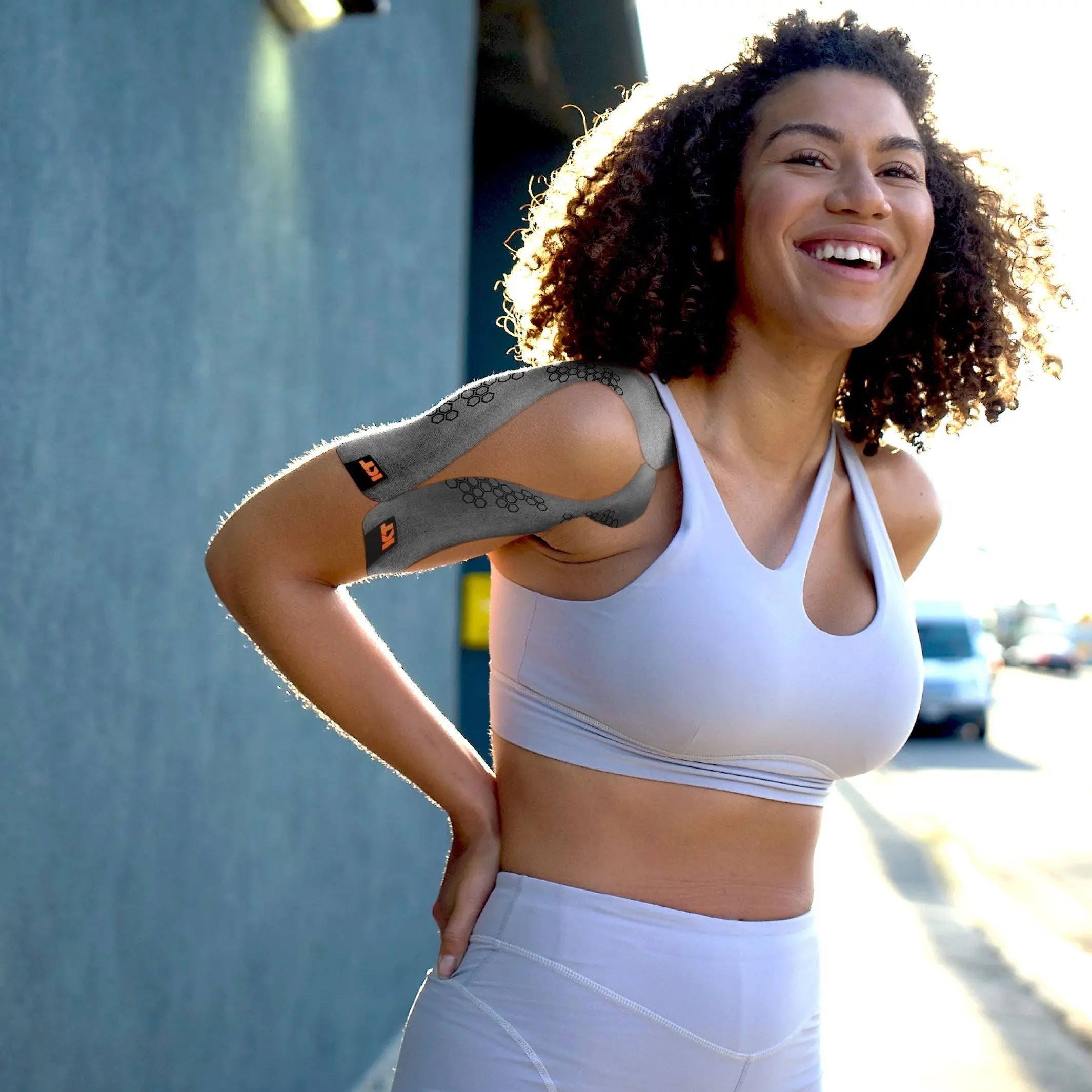 Woman smiling after running, wearing KT Tape Pro Oxygen